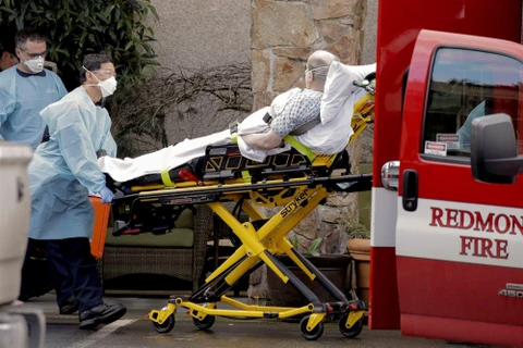 Nhân viên y tế chuyển bệnh nhân nhiễm COVID-19 lên xe cứu thương tại Kirkland, bang Washington, Mỹ ngày 3/3/2020. (Ảnh: Reuters/TTXVN)