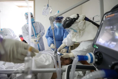 Nhân viên y tế điều trị cho bệnh nhân nhiễm COVID-19 tại bệnh viện ở Vũ Hán, Trung Quốc, ngày 16/2. (Ảnh: AFP/TTXVN)