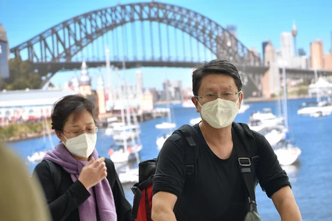 Hành khách đeo khẩu trang phòng lây nhiễm COVID-19 tại sân bay Sydney, Australia ngày 23/1/2020. (Ảnh: AFP/TTXVN)