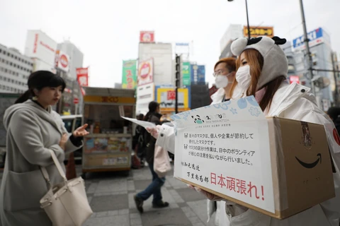 Phát khẩu trang miễn phí để phòng tránh lây nhiễm COVID-19 tại Tokyo, Nhật Bản, ngày 7/3. (Ảnh: THX/TTXVN)