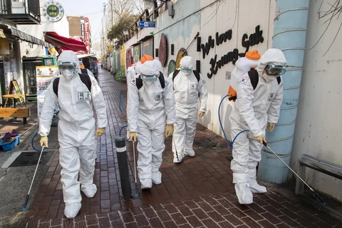 Binh sỹ Hàn Quốc mặc trang phục bảo hộ phun khử trùng một tuyến phố ở thành phố Daegu ngày 5/3/2020. (Ảnh: THX/TTXVN)