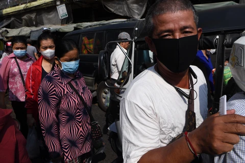 Người dân đeo khẩu trang phòng lây nhiễm COVID-19 tại Phnom Penh, Campuchia, ngày 14/3. (Ảnh: AFP/TTXVN)