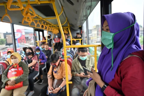 Hành khách đeo khẩu trang phòng lây nhiễm COVID-19 tại Jakarta, Indonesia, ngày 18/3/2020. (Ảnh: AFP/TTXVN)
