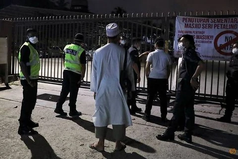 Cảnh sát Malaysia đứng bên ngoài Nhà thờ Hồi giáo Seri Petaling tại Kuala Lumpur, nơi nổi lên như một nguồn lây nhiễm hàng trăm ca bệnh COVID-19 mới trên khắp Đông Nam Á. (Nguồn: Reuters)