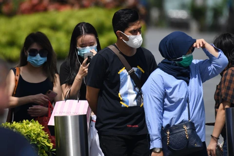 Người dân đeo khẩu trang phòng dịch COVID-2 tại Singapore ngày 4/2/2020. (Ảnh: AFP/TTXVN)