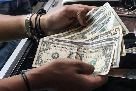  Người dân sử dụng đồng đô la Mỹ để thanh toán tại nhà hàng ở Caracas, Venezuela, ngày 18/3/2019. Ảnh: AFP/ TTXVN 