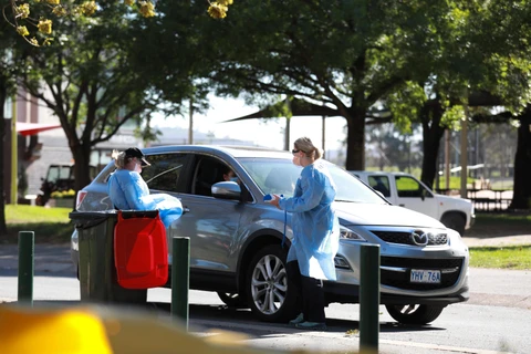 Nhân viên y tế kiểm tra thân nhiệt cho người dân tại Canberra, Australia ngày 20/3/2020, trong bối cảnh dịch COVID-19 lan rộng. (Ảnh: THX/ TTXVN)