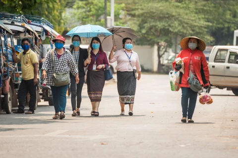Người dân đeo khẩu trang nhằm ngăn chặn sự lây lan của dịch COVID-19 tại thủ đô Vientiane, Lào ngày 23/3/2020. (Ảnh: THX/TTXVN)