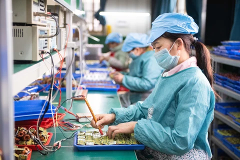 Công nhân kiểm tra linh kiện điện tử tại một nhà máy ở huyện Đào Viên, tỉnh Hồ Nam, Trung Quốc ngày 20/2/2020. (Ảnh: THX/TTXVN)