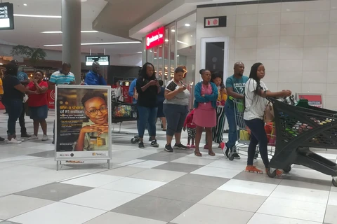 Người dân xếp hàng trong trung tâm thương mại Menlyn tại thủ đô Pretoria tối 26/3 để mua lương thực, thực phẩm tích (Ảnh: Phi Hùng/TTXVN)