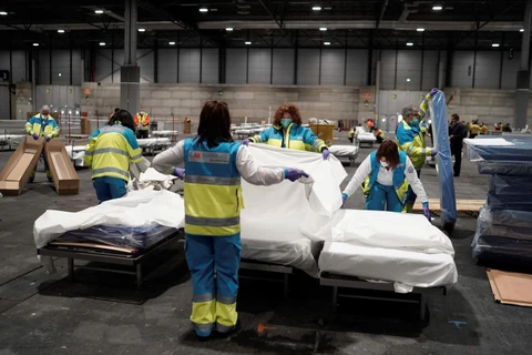 Nhân viên y tế chuẩn bị giường nằm cho bệnh nhân nhiễm COVID-19 tại bệnh viện dã chiến ở Madrid, Tây Ban Nha, ngày 22/3/2020. (Ảnh: THX/TTXVN)