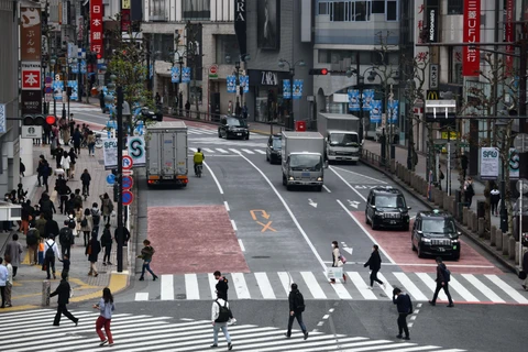 Người dân di chuyển trên đường phố tại Tokyo, Nhật Bản ngày 28/3/2020. (Ảnh: AFP/ TTXVN)