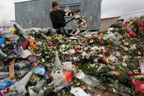 Một nhân viên của một cửa hàng hoa tiêu hủy những bông hoa chưa bán ở Saint Petersburg. (Nguồn: channelnewsasia.com)