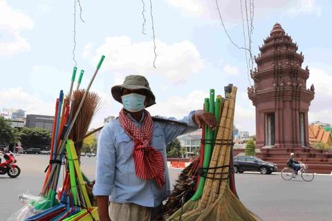 Người dân đeo khẩu trang phòng lây nhiễm COVID-19 trên một đường phố ở Phnom Penh, Campuchia, ngày 25/3/2020. (Ảnh: THX/TTXVN)