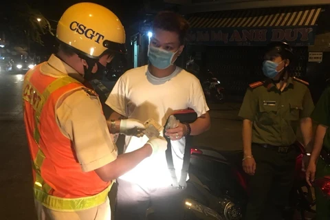 Công an thành phố Nha Trang tuần tra kết hợp tuyên truyền, nhắc nhở các trường hợp tham gia giao thông tuân thủ các quy định phòng chống dịch bệnh COVID-19. (Ảnh: Phan Sáu/TTXVN)