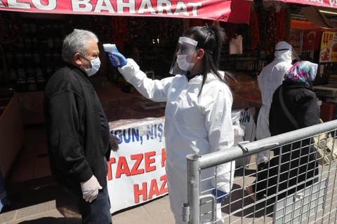 Kiểm tra thân nhiệt nhằm ngăn chặn sự lây lan của dịch COVID-19 tại một chợ ở Ankara, Thổ Nhĩ Kỳ, ngày 17/4/2020. (Ảnh: THX/TTXVN)