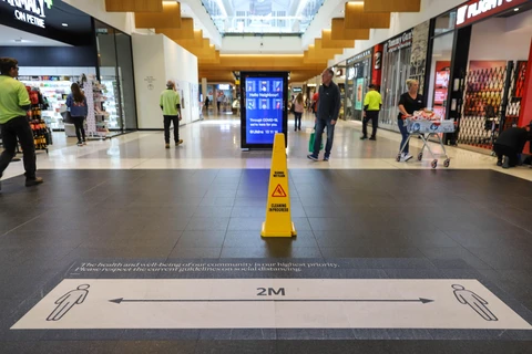 Bảng nhắc nhở người dân thực hiện giãn cách xã hội để phòng lây nhiễm COVID-19 tại trung tâm thương mại ở Canberra, Australia, ngày 6/4/2020. (Ảnh: THX/TTXVN)