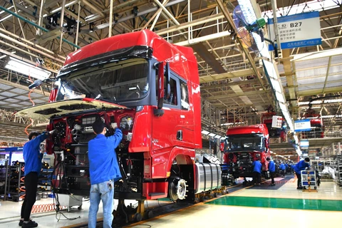 Công nhân làm việc tại dây chuyền sản xuất xe tải hạng nặng của Tập đoàn sản xuất ôtô Thiểm Tây, Trung Quốc ngày 23/4/2020. (Ảnh: THX/TTXVN)