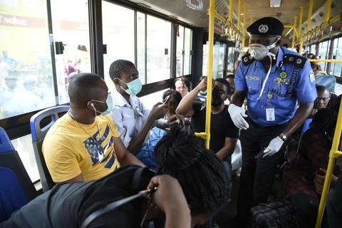 Cảnh sát nhắc nhở người dân các biện pháp phòng lây nhiễm COVID-19 tại Lagos, Nigeria. (Ảnh: AFP/TTXVN)