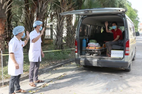 Các y bác sỹ Bệnh viện Đa khoa huyện Kim Sơn chào tạm biệt bệnh nhân nhiễm Covid-19 cuối cùng điều trị tại Ninh Bình được xuất viện. (Ảnh: Thùy Dung/TTXVN)