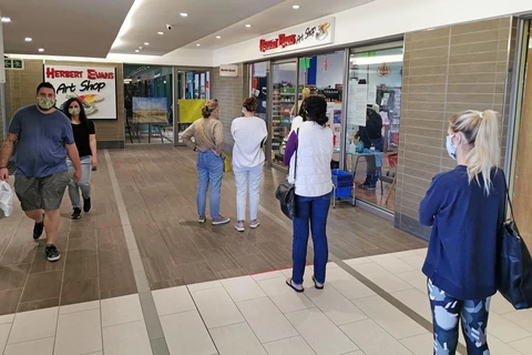 Người dân thực hiện giãn cách xã hội phòng lây nhiễm COVID-19 khi xếp hàng bên ngoài một cửa hàng ở Johannesburg, Nam Phi ngày 2/5/2020. (Ảnh: THX/TTXVN)