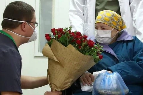 Bác sỹ tặng hoa cụ bà Pelageya Poyarkova trước khi xuất viện. (Nguồn: AFP)