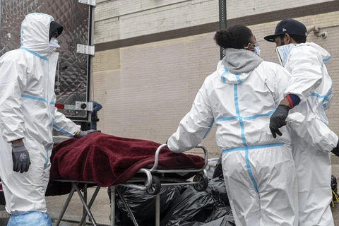 Nhân viên y tế chuyển thi thể bệnh nhân mắc COVID-19 tới nhà tang lễ ở Brooklyn, New York, Mỹ ngày 30/4/2020. (Ảnh: AFP/TTXVN)