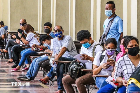 Người dân đeo khẩu trang phòng lây nhiễm COVID-19 khi xếp hàng bên ngoài bưu điện ở Manila, Philippines. (Ảnh: THX/ TTXVN)