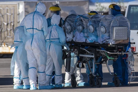 Nhân viên y tế chuyển bệnh nhân COVID-19 tới bệnh viện tại Santiago, Chile, ngày 24/5/2020. (Ảnh: AFP/TTXVN)