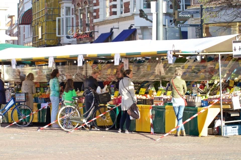 Người dân thực hiện giãn cách xã hội phòng lây nhiễm COVID-19 khi mua thực phẩm tại chợ ở Haarlem, Hà Lan ngày 11/4/2020. (Ảnh: THX/TTXVN)