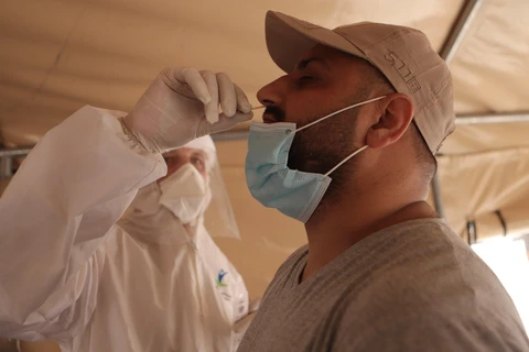 Nhân viên y tế lấy mẫu xét nghiệm COVID-19 tại Hebron, Khu Bờ Tây, Mỹ. (Ảnh: THX/TTXVN)