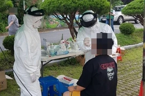 Nhân viên y tế lấy mẫu dịch xét nghiệm COVID-19 cho người dân tại Okcheon, tỉnh Bắc Chungcheong, Hàn Quốc ngày 28/6/2020. (Ảnh: Yonhap/TTXVN)