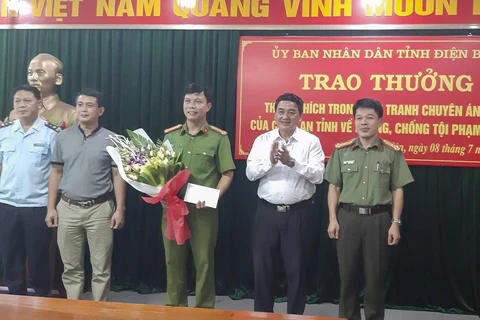 Phó Chủ tịch UBND tỉnh Điện Biên Lê Văn Qúy (thứ 2, từ phải qua trái) khen thưởng cho các thành viên của Ban chuyên án. (Ảnh: TTXVN)