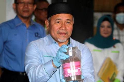 Bộ trưởng Nước và Môi trường Malaysia Tuan Ibrahim Tuan Man cầm trên tay mẫu bụi lò thép độc hại trong các container tại Cảng Tanjung Pelepas ngày 19/7. (Nguồn: thestar.com.my)