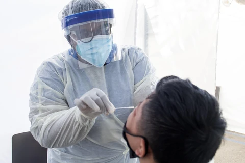Nhân viên y tế lấy mẫu dịch xét nghiệm COVID-19 cho người dân tại bang California, Mỹ ngày 24/7/2020. (Ảnh: AFP/TTXVN)