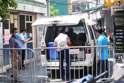 Lực lượng chức năng phong tỏa khu vực ngõ 230/26 Mễ Trì Thượng, Hà Nội - nơi có trường hợp nghi nhiễm COVID-19 đang sinh sống để phun thuốc khử khuẩn. (Ảnh: Lê Phú/TTXVN)