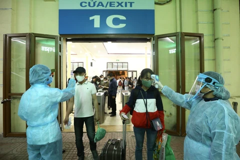 Hành khách được đo thân nhiệt trước khi vào ga Hà Nội. (Ảnh: Minh Quyết/TTXVN)