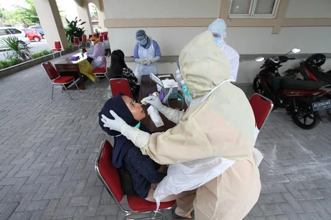 Nhân viên y tế lấy mẫu dịch xét nghiệm COVID-19 cho người dân tại Surakarta, Trung Java, Indonesia ngày 4/8/2020. (Ảnh: THX/TTXVN)
