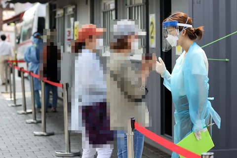 Người dân chờ xét nghiệm COVID-19 tại Seoul, Hàn Quốc ngày 17/8/2020. (Ảnh: Yonhap/ TTXVN)