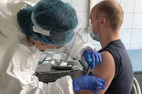 Nhân viên y tế tiêm vaccine ngừa COVID-19 cho tình nguyện viên tại Nga. (Ảnh: TASS/TTXVN)