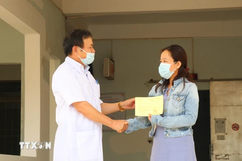 Tiến sỹ-bác sỹ Châu Đương, Giám đốc Bệnh viện Lao và bệnh phổi tỉnh Đắk Lắk trao giấy xuất viện cho bệnh nhân 601. (Ảnh: Tuấn Anh/TTXVN)