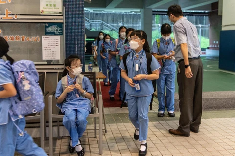 Học sinh Hong Kong đeo khẩu trang, rửa tay bằng dung dịch sát khuẩn khi trở lại trường học. (Nguồn: NPR)