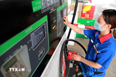 Nhân viên bơm xăng cho phương tiện tại một trạm xăng ở Hà Bắc, Trung Quốc. (Ảnh: THX/TTXVN)