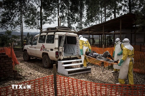 Nhân viên y tế chuyển bệnh nhân nhiễm virus Ebola lên xe cứu thương tại Butembo, CHDC Congo. (Ảnh: AFP/TTXVN)