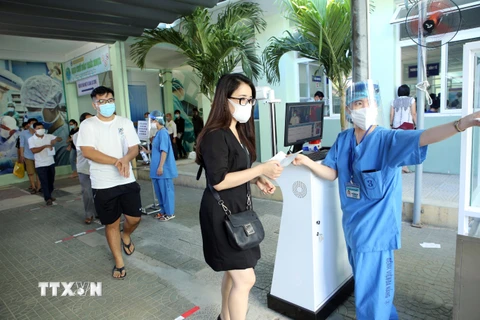 Hướng dẫn người dân đến khám bệnh tại Bệnh viện Đà Nẵng. (Ảnh: Trần Lê Lâm/TTXVN)