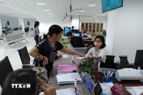 Người dân nộp hồ sơ làm thủ tục tư pháp tại Trung tâm Phục vụ hành chính công tỉnh Tiền Giang. (Ảnh: Minh Hưng/TTXVN)