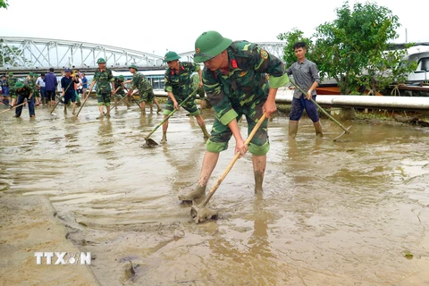 Cán bộ, chiến sỹ cùng người dân khẩn trương dọn vệ sinh sau mưa lũ tại Thừa Thiên-Huế. (Ảnh: Tường Vi/TTXVN)