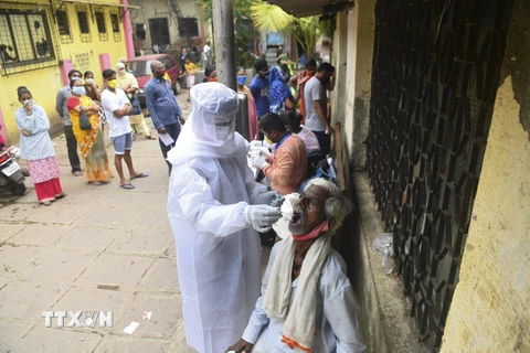 Nhân viên y tế lấy mẫu dịch xét nghiệm COVID-19 cho người dân tại Mumbai, Ấn Độ, ngày 12/10/2020. (Ảnh: AFP/TTXVN) 