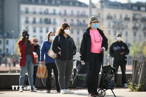 Người dân đeo khẩu trang phòng dịch COVID-19 tại Geneva, Thụy Sĩ. (Ảnh: AFP/TTXVN)