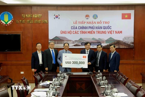 Ông Park Noh-Wan, Đại sứ Hàn Quốc tại Việt Nam trao tượng trưng gói hỗ trợ 300.000 USD cho Ủy viên Ban Chỉ đạo Trung ương về Phòng, chống thiên tai Nguyễn Hoàng Hiệp. (Ảnh: Vũ Sinh/TTXVN)
